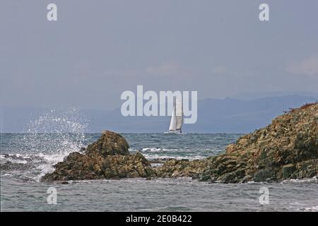 Un yacht s'approche de la partie accidentée de la côte de l'île de Tabarca. Ce n'est pas le meilleur endroit pour être s'il y a des vents sur terre - un rivage de lee. Banque D'Images