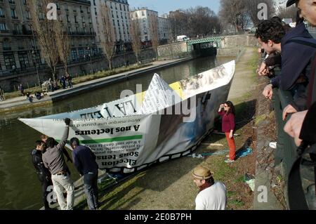 Un bateau à papier de 9 mètres sur le Canal Saint-Martin à Paris, en France, le 14 mars 2012, pour le lancement de la nouvelle version du journal Metro. Photo d'Alain Apaydin/ABACAPRESS.COM Banque D'Images