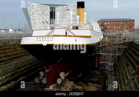 SS Nomadic, le dernier navire White Star Line restant est actuellement en cours de restauration à Hamilton Dock, en face du bâtiment Titanic Belfast, qui célèbre l'histoire du port de Belfast, à Belfast, au Royaume-Uni, en mars 2012. Le 10 avril 1912, le bateau a transporté 142 passagers de première et deuxième classe au Titanic depuis le port de Cherbourg. Conçue par Thomas Andrews, l'architecte du Titanic, elle a été construite à Harland & Wolff sous le profil géant du Titanic et de l'Olympic par les mêmes ouvriers. Après avoir servi olympique pendant des années , le bateau a atteint la Seine et est devenu une boîte de nuit ! Elle est retournée à Belfast en 2006 an Banque D'Images