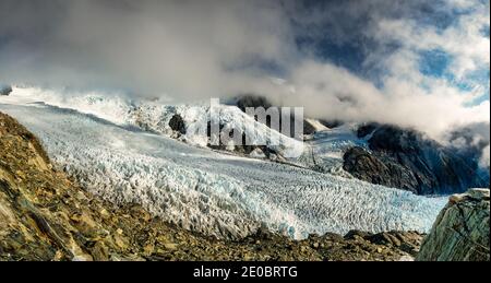 Vue sur le bord jusqu'au glacier François-Joseph au-dessous et les montagnes enveloppées dans le nuage entrant au-delà Banque D'Images