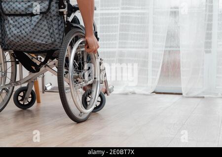 Un homme handicapé assis dans un fauteuil roulant est déçu et désespéré de guérir après un accident de voiture. Concept de conduite négligente, d'assurance et de santé mentale Banque D'Images