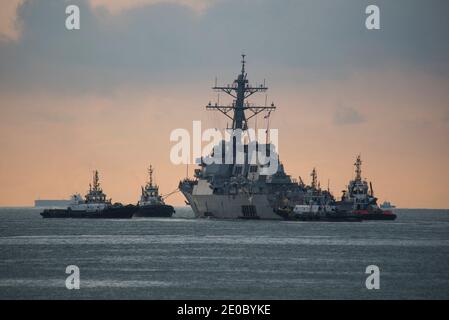 Document photo du dossier daté du 5 octobre 2017 du destroyer de missile guidé de classe Arleigh Burke USS John S. McCain (DDG 56) est remorqué loin de la jetée de la base navale de Changi, à Singapour. Deux navires de guerre américains ont traversé le détroit sensible de Taiwan jeudi pour protester contre Beijing, la deuxième mission de ce mois-ci et qui a lieu près de deux semaines après qu'un groupe de porte-avions chinois ait utilisé la même voie navigable. La Marine américaine a déclaré que les destroyers guidés de missiles USS John S. McCain et USS Curtis Wilbur avaient 'effectué un transit régulier du détroit de Taiwan le 31 décembre conformément au droit international'. ÉTATS-UNIS Banque D'Images