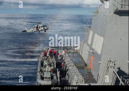 Document de dossier photo datée du 18 mars 2015 d'un hélicoptère MH-60S Sea Hawk affecté à l'Escadron de combat de la mer (HSC) 25 des chevaliers de l'île se prépare à atterrir sur le pont de vol du destroyer de missile guidé de classe Arleigh Burke USS Curtis Wilbur (DDG 54) pendant une qualification d'atterrissage sur pont. Deux navires de guerre américains ont traversé le détroit sensible de Taiwan jeudi pour protester contre Beijing, la deuxième mission de ce mois-ci et qui a lieu près de deux semaines après qu'un groupe de porte-avions chinois ait utilisé la même voie navigable. La Marine américaine a déclaré que les destroyers de missiles guidés USS John S. McCain et Banque D'Images