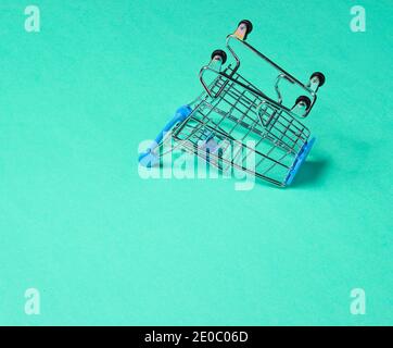 Concept de shopping minimaliste. Chariot à provisions miniature inversé vide sur fond bleu Banque D'Images