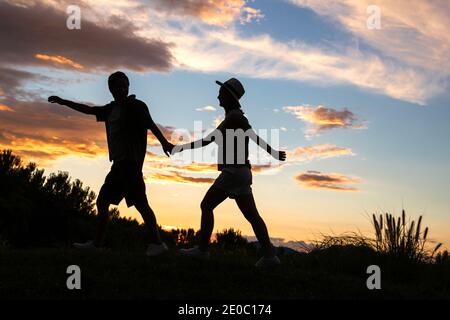 Le couple heureux au coucher du soleil Banque D'Images