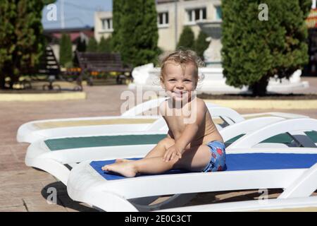 Garçon reposant sur un fauteuil inclinable à l'Aquapark en été Banque D'Images