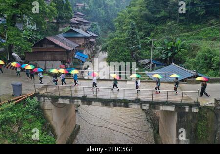 Ronghui, Chine. 31 décembre 2020. La photo aérienne prise le 3 juin 2020 montre que des femmes marchent sur un nouveau pont sur leur chemin de retour dans le village de Wuying, un village isolé habité par le groupe ethnique Miao à la frontière entre la région autonome de Guangxi Zhuang dans le sud de la Chine et la province de Guizhou dans le sud-ouest de la Chine. Situés dans une vallée profonde de cette région montagneuse, les habitants de Wuying ont souffert des terres arides de la région, de l'environnement naturel inondé et des infrastructures de transport peu pratiques. Credit: Xinhua/Alay Live News Banque D'Images