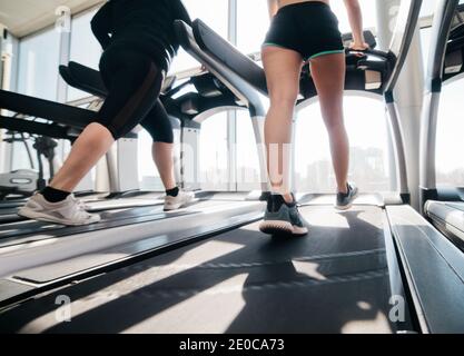 Vêtements de sport pour femme et baskets sur tapis roulant la salle de sport contre la fenêtre Banque D'Images