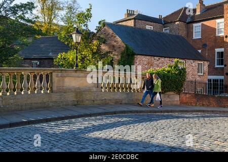 Pont FOSS et pittoresque rue pavée dans York - (balustres en pierre historique, coucher de soleil sur la route, personnes marchant) - North Yorkshire, Angleterre, Royaume-Uni. Banque D'Images