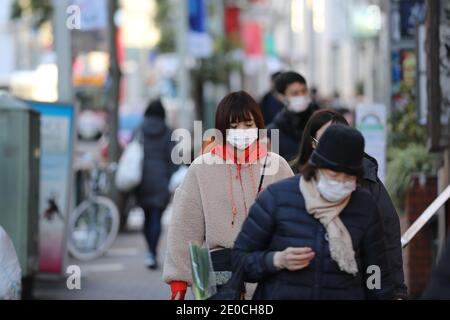 Tokyo, Japon. 31 décembre 2020. Des piétons portant des masques faciaux marchent sur une route à Tokyo, Japon, 31 décembre 2020. Le nombre de nouveaux cas quotidiens de COVID-19 à Tokyo a dépassé le seuil des 1,000 pour la première fois depuis l'épidémie, a déclaré le gouverneur Yuriko Koike jeudi, avertissant que la troisième vague qui frappe la capitale est de « taille sans précédent ». Credit: Du Xiaoyi/Xinhua/Alay Live News Banque D'Images