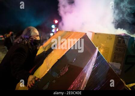 Minneapolis, Minnesota, États-Unis. 31 décembre 2020. Un homme jette des boîtes sur un incendie que les manifestants ont commencé à garder au chaud tout en confrontant la police au-dessus de l'agent impliqué de fusillade qui a pris la vie de quelqu'un la veille. La scène de la fusillade est à 1,5 kilomètre de l'endroit où George Floyd a été tué par la police en mai 2020. Credit: Chris Juhn/ZUMA Wire/Alay Live News Banque D'Images