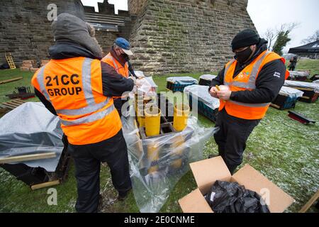 Stirling, Écosse, Royaume-Uni. 31 décembre 2020. Photo : experts pyrotechniques du Monument Wallace. Des experts pyrotechniques de 21CC Fireworks, une société d'événements basée à Édimbourg, chargent soigneusement les obus de mortier dans leurs tubes de lancement alors qu'ils se préparent pour ce soir Hogmanay pyro spectaculaire qui illuminera le ciel à 600 mètres au-dessus du Monument Wallace. Un spectacle de lumière projeté sur la façade du Monument Wallace accompagnera les feux d'artifice. En raison de la pandémie du coronavirus (COVID19), le spectacle sera diffusé en direct à la télévision et en ligne depuis que l'Écosse est en phase 4 verrouillée. Crédit : Colin Fisher Banque D'Images