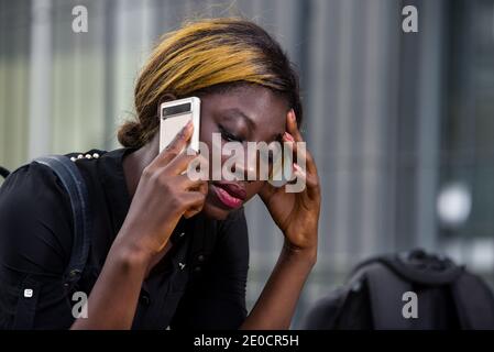 gros plan d'un jeune étudiant triste et ayant du problème à parler le téléphone se déchête dans la ville en plein jour Banque D'Images