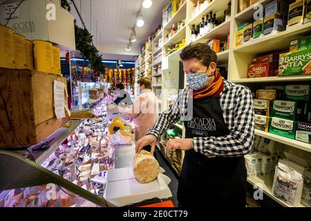 Mark Brown propriétaire de l'Arcadia, un magasin indépendant de fine food à Belfast, coupe dans le camion de stilton bleu produit producteur anglais Colston Bassett. Les fromages britanniques peuvent devenir rares sur les tablettes des épiceries fines d'Irlande du Nord, à moins qu'une offre de fraîcheur ne soit acceptée, a déclaré le propriétaire de l'entreprise. Banque D'Images