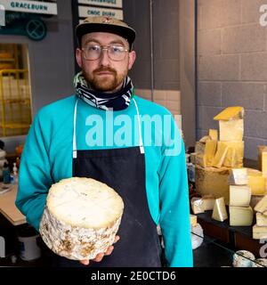 Michael Thomson, de Mike's Fancy Cheese à Belfast, tenant un demi-camion de Young Buck, un fromage bleu de lait cru fabriqué à Newtownards, en Irlande du Nord. Les fromages britanniques peuvent devenir une rareté sur les étagères des épiceries fines d'Irlande du Nord, à moins qu'une offre de fraîcheur ne soit acceptée, a déclaré un propriétaire d'entreprise. Banque D'Images