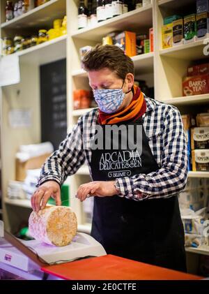 Mark Brown propriétaire de l'Arcadia, un magasin indépendant de fine food à Belfast, coupe dans le camion de stilton bleu produit producteur anglais Colston Bassett. Les fromages britanniques peuvent devenir rares sur les tablettes des épiceries fines d'Irlande du Nord, à moins qu'une offre de fraîcheur ne soit acceptée, a déclaré le propriétaire de l'entreprise. Banque D'Images