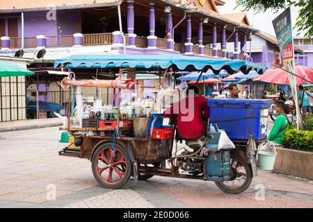 Les hommes thaïlandais sont assis sur tricycle chariot vente boissons non alcoolisées de l'eau et du café ancien au centre du marché local, au bord de la rivière Rivière Sakae Krang à Uthathani cit Banque D'Images