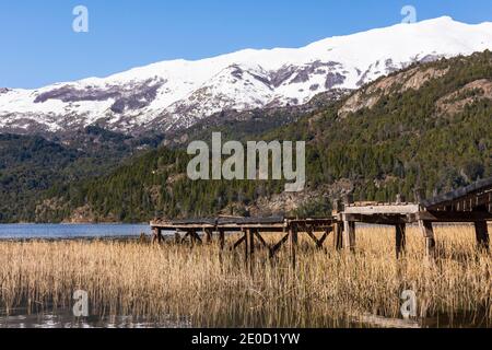 Vue sur la scène de l'ancienne jetée en bois contre les montagnes enneigées des Andes dans le lac vert (Lago Verde) dans le parc national de Los Alerces, Patagonia, Argentine Banque D'Images