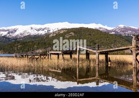 Vue sur la scène de l'ancienne jetée en bois contre les montagnes enneigées des Andes dans le lac vert (Lago Verde) dans le parc national de Los Alerces, Patagonia, Argentine Banque D'Images