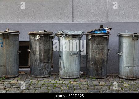 Des poubelles métalliques sont alignées dans la ruelle arrière de Cesky Krumlov, République tchèque. Banque D'Images