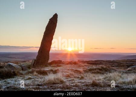 Ancienne pierre périphérique (début 1700) sur Blakey Rigg, en regardant vers l'est au lever du soleil dans le parc national des Moors de North York. Monolithl de forme rugueuse. Les lettres Banque D'Images