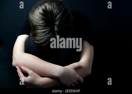 adolescent assis dans une posture fermée éprouvant des problèmes de santé mentale Comme la dépression pendant le verrouillage de COVID-19 Banque D'Images