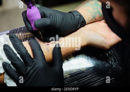 Vue latérale d'un homme sérieux dans des vêtements décontractés à proximité mur du bâtiment en ville et regarder la caméra Banque D'Images