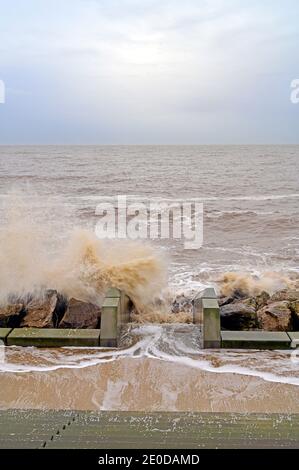 Les vagues se brisent sur des marches concrètes dans les défenses marines Banque D'Images