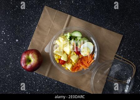 De la partie supérieure de divers légumes délicieux et œufs durs placés dans un récipient en plastique pour les aliments à emporter Banque D'Images