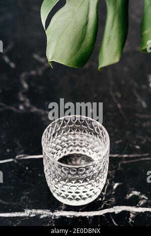 Grand angle de verre à facettes avec de l'eau douce table en marbre près de l'usine de monstère Banque D'Images