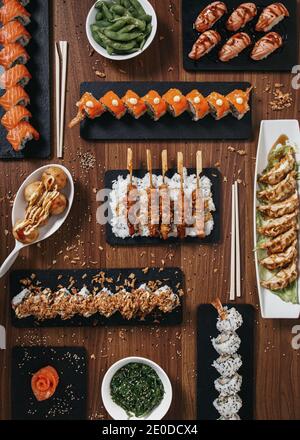Vue de dessus de l'assortiment de sushis et de petits pains disposés sur du bois Table au restaurant avec cuisine asiatique Banque D'Images