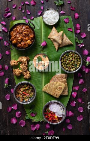 Des plats variés de cuisine indienne sont proposés Une énorme feuille de banane pour célébrer Onam Sadhya Banque D'Images