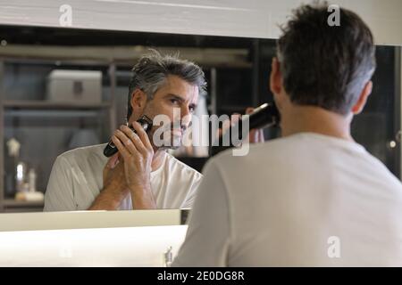 Photo de l'homme beau qui se rabe dans la salle de bains à la maison. Banque D'Images