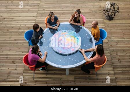 Par-dessus le groupe d'amis assis autour de la table terrasse et parler entre eux tout en appréciant le week-end ensemble Banque D'Images