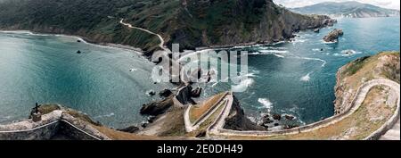 Depuis le dessus de la passerelle étroite construite sur les montagnes séparant l'océan avec des vagues formant de la mousse sous ciel nuageux Banque D'Images
