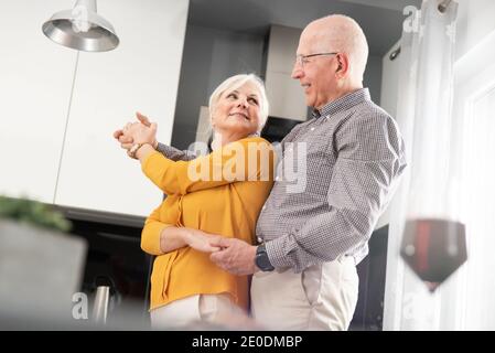 Senior couple dancing and smiling at home. Heureux couple de retraités Banque D'Images