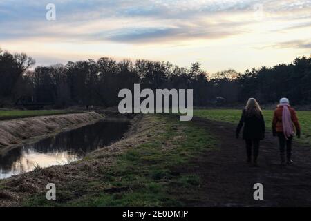 Berlin, Allemagne. 31 décembre 2020. Personnes marchant le long de la rivière Erpe sous le soleil du soir. Credit: Kira Hofmann/dpa-Zentralbild/dpa/Alay Live News Banque D'Images