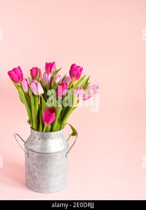 bouquet de tulipes roses de printemps dans un vase sur fond rose. Toile de fond de vacances, espace de copie pour la fête des mères de Saint-Valentin, concept d'anniversaire. Banque D'Images