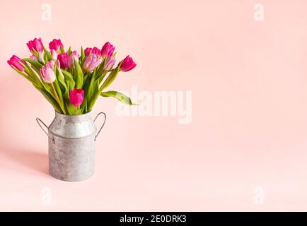 bouquet de tulipes roses de printemps dans un vase sur fond rose. Arrière-plan de vacances, espace de copie pour la fête des mères de Saint-Valentin, concept d'anniversaire. Banque D'Images
