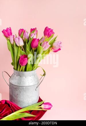 Composition verticale de printemps, arrangements de tulipes dans un vase sur un fond rose pastel, cadre, bordure, jolie carte avec fleurs Ressources graphiques FO Banque D'Images