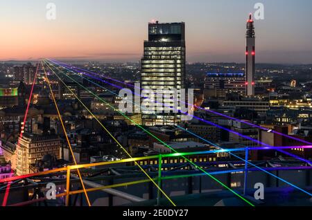 Birmingham, Royaume-Uni. 31 décembre 2020. Global Rainbow C une installation artistique de l'artiste international Yvette Mattern - a été retransmise au nord-ouest du bâtiment emblématique de la Rotunda ce soir, marquant un message d'espoir et de paix pour le nouvel an. La photo montre la vue sur la ville depuis le sommet de la Rotunda. Global Rainbow faisceaux sept rayons de lumière laser (rouge, orange, jaune, vert, bleu, indigo et Violet) représentant le spectre de couleurs d'un arc-en-ciel naturel et seront shone au nord-ouest de la ville au cours de la période du nouvel an. Crédit : Simon Hadley/Alamy Live News Banque D'Images