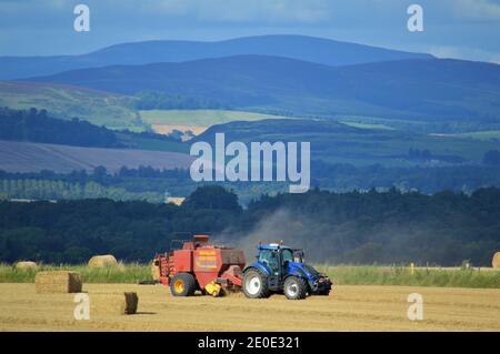 Pressage de gros carrés de tracteur Valtra - Farming Perthshire Banque D'Images
