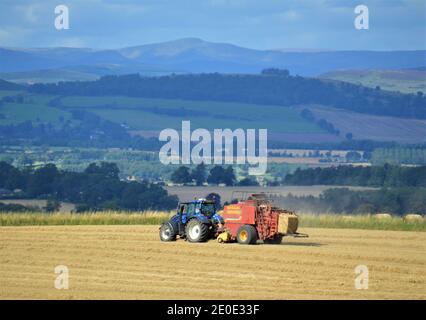 Pressage de gros carrés de tracteur Valtra - Farming Perthshire Banque D'Images