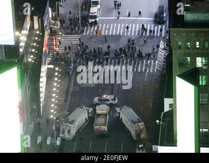 New York, États-Unis. 31 décembre 2020. Les fêtards essaient d'avoir un aperçu à travers les camions d'assainissement stationnés dans Times Square qui est fermé au public pour la célébration du nouvel an en raison de la pandémie du coronavirus à New York le jeudi 31 décembre 2020. En raison de la pandémie COVID-19 en cours, la Saint-Sylvestre 2021 à Times Square ne sera pas ouverte au public cette année. Photo de John Angelillo/UPI crédit: UPI/Alay Live News Banque D'Images