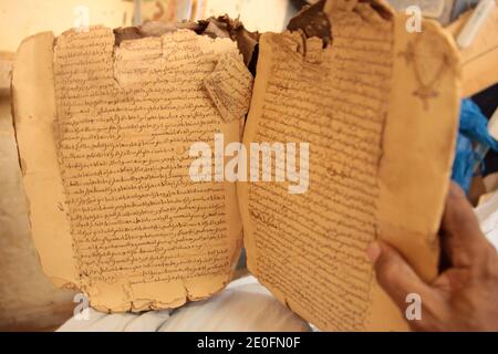 Les troupes françaises et maliennes sont entrées lundi 28 janvier 2013 à Tombouctou, un site classé au patrimoine mondial de l'UNESCO, après avoir fui les combattants rebelles islamistes qui ont torqué plusieurs bâtiments dans l'ancienne ville commerçante du Sahara, dont une bibliothèque de manuscrits inestimable. Sans tirer dessus pour les arrêter, 1,000 soldats français, dont des parachutistes et 200 soldats maliens, se sont emparés de l'aéroport et ont encerclé la ville du fleuve Niger, vieille de plusieurs siècles, cherchant à bloquer la fuite des combattants alliés d'Al-Qaïda. Photo du fichier : un manuscrit ancien est photographié à Tombouctou, au Mali, en octobre 2009. Tombouctou, la ville historique du Mali et le Banque D'Images