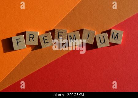 Freemium, slogan marketing, une combinaison de Free et Premium, en lettres de l'alphabet de bois isolées sur fond rouge et orange Banque D'Images