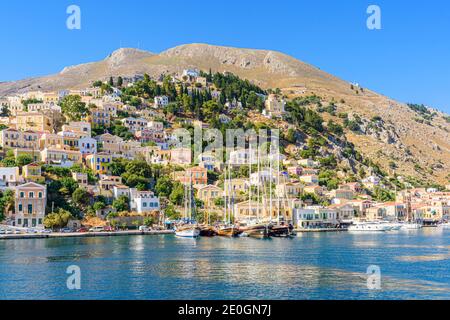 Symi vue sur la ville des bateaux amarrés le long du front de mer sur l'île de Symi, Dodécanèse, Grèce Banque D'Images