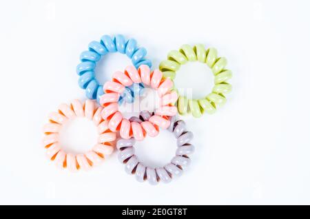 Groupe de bandes en caoutchouc spirales colorées. Attaches élastiques aux couleurs vives sur fond blanc. Banque D'Images