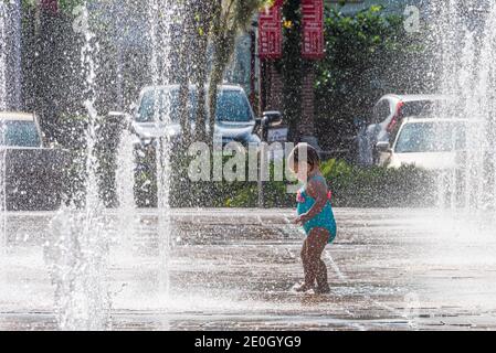 Tout-petit appréciant la fontaine et le Splashpad interactifs du jardin d'hiver dans le centre-ville de Winter Garden, Floride. (ÉTATS-UNIS) Banque D'Images