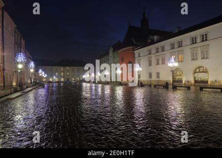 Nuit citrycsape de la petite place vide à Cracovie, Pologne, décoré avec des décorations de rue de Noël, vide, séché de raison pandémique. Banque D'Images